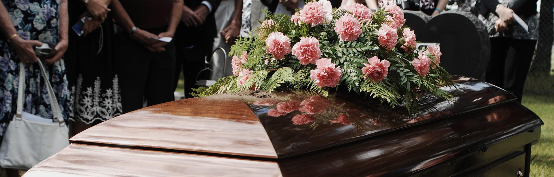 #1 Ozdobiona ciemnobrązowa drewniana trumna podczas ceremonii pogrzebu na cmentarzu